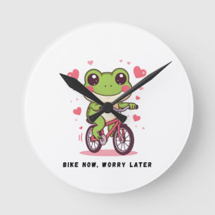 Söt groda som cyklar Roligt present till grodäls Rund Klocka