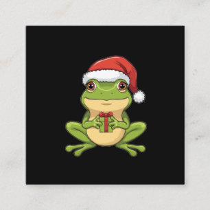 Söt julgroda med tomteluva som håller present - tilläggskort