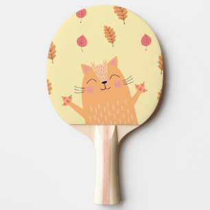 Söt orange katt leker i höstlöv pingisracket