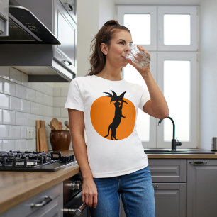 Söt svart katt i orange tomat på vit trendig t shirt