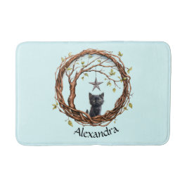 Söt svart kattunge som tittar på en stjärna badrumsmatta