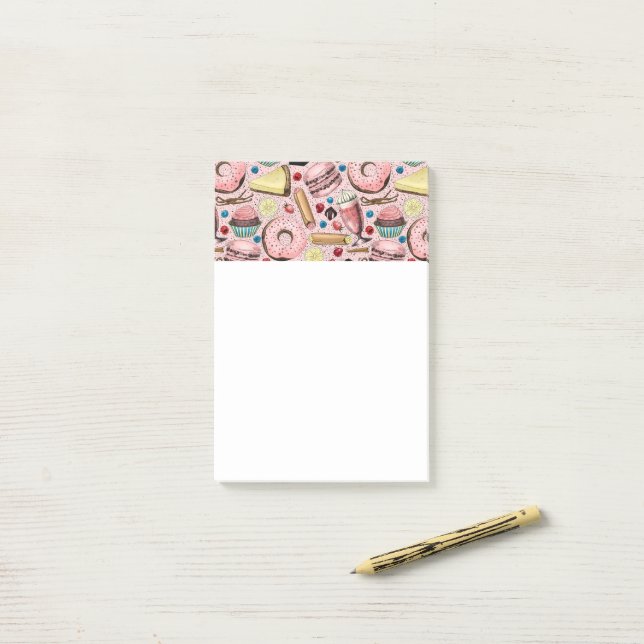 Söta behandlingar på rosa post-it block (På skrivbordet)