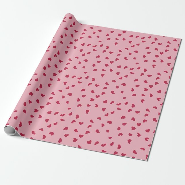 Söta spridda röda hjärtan doodles på rosa presentpapper (Utrullad)