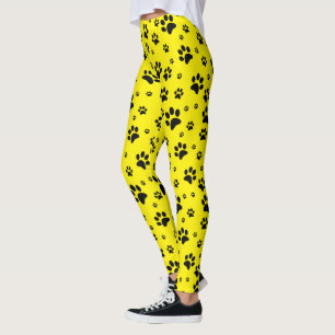 Söta svarta tassavtryck på ljusgul bakgrund leggings