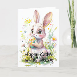 Sött kanin som håller påskägg och blommor helgkort