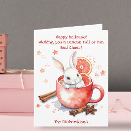 Sött kaninblickande från en röd kopp julen kort