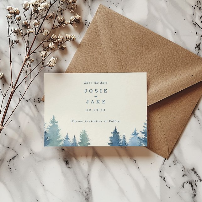 Spara datumet för Soft gräs träd (Soft pine trees save the date card with bride and groom name and date next to a brown envelope.)