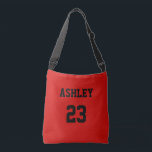 Sports Jersey Number och Namn Red Personlig Axelväska<br><div class="desc">Ett jersey nummer och namn i svart på röd bakgrund. Både namn och nummer kan vara personliger i textrutan. Färg i texten kan ändras på redigeringsmenyn innan du checkar ut.</div>