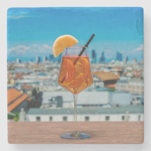 Spritz-cocktail på bord mot Milano Stenunderlägg