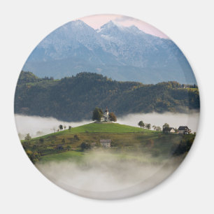 St Thomas kyrka med berg i den Slovenien rundan Magnet