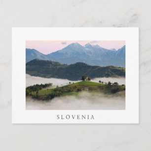 St. Thomas kyrka med berg i Slovenien vit Vykort