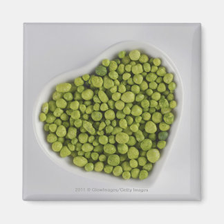 Stängning av småstarna av grönt i en hjärtformskål magnet