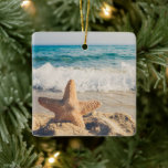 Starfish on a Sandy Beach Photographic Julgransprydnad Keramik<br><div class="desc">En ornament med ett scenfoto. En stor stjärnfisk satte sig upprätt på en sandstrand. Ett vackert blåhav med vågar av vit surfa i bakgrunden.</div>