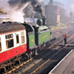 STEAM TÅG KAKELPLATTA<br><div class="desc">En vackert återvunnen ånga tåg och vagnar från en gammal tid som lämnar station och motorföraren händer över nyckel innan de tillåts fortsätta längs järnvägen. England UK.</div>
