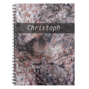 Stenstruktur som är pinkish med någon text anteckningsbok med spiral