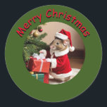 Sticker - Mouse Santa Runt Klistermärke<br><div class="desc">Mus klädd i Santa Kostym levererar paket under träd. Texten "god jul" i rött med en svart skugga på en medelstor grönt. #generativeccontent</div>