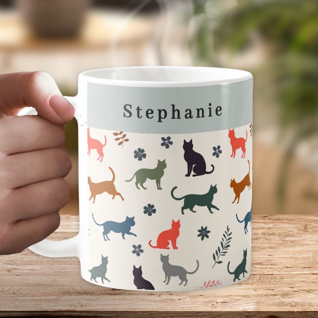 Stiliga Katter Mönster Personlig Kaffemugg (A personalized coffee mug, with a pattern of cat silhouettes in warm and neutral colors)