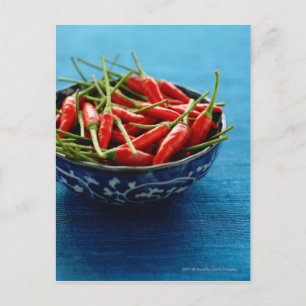 Stilleben med chilipeppar i skål på blå matta vykort