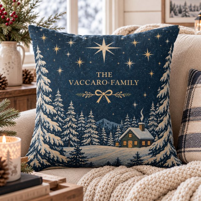 Stjärnklar vinterstuga med anpassat efternamn kudde (Custom family name holiday pillow featuring a starry night winter cabin and snowy pine trees.)