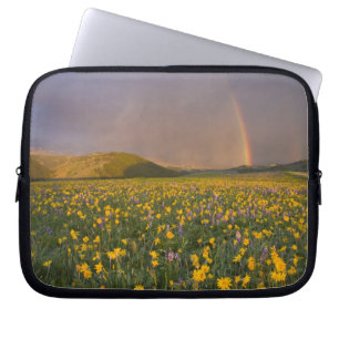 Storslagen äng med vilda blommor vid soluppgången laptop sleeve