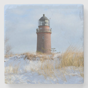 Sturdy Lighthouse på en Rocky Kusten på vinter Stenunderlägg