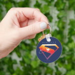 Sunset Soar Superman Shield Nyckelring<br><div class="desc">Lägg till en kosmisk vrid till din superhjälte stil med den strålande supermansdesignen! Den klassiska "S"-skölden glor mot en djup marin bakgrund i en varm övertoning av orange, gyllene gulter och solnedgången rosa - som fångar skönheten i Supermans makt och hopp. En silhuett av Superman strömmar över emblemet i en...</div>