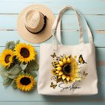 Sunshine Be the Sunshine Sunflower | Tygkasse<br><div class="desc">This tote bag features a clean, modern design with a soft, uplifting aesthetic. The bag itself is white with sturdy black shoulder straps, creating a nice contrast that makes the artwork stand out. The front showcases a large, beautifully detailed sunflower in rich golden and amber tones, with layered petals and...</div>