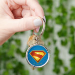 Superman Golden S Shield Brilliance Rund Silverfärgad Nyckelring<br><div class="desc">Skina upp med den legendariska hoppsymbolen! Den här fantastiska designen har den ikoniska Superman "S"-skölden som återges i strålande guld och djup svärta, som ger en heroisk intensitet mot en fetblå bakgrund. Den eleganta metallövertoningen för avsluta och rik färg är ge en symbol för ett mäktigt, modernt kant - perfekt...</div>