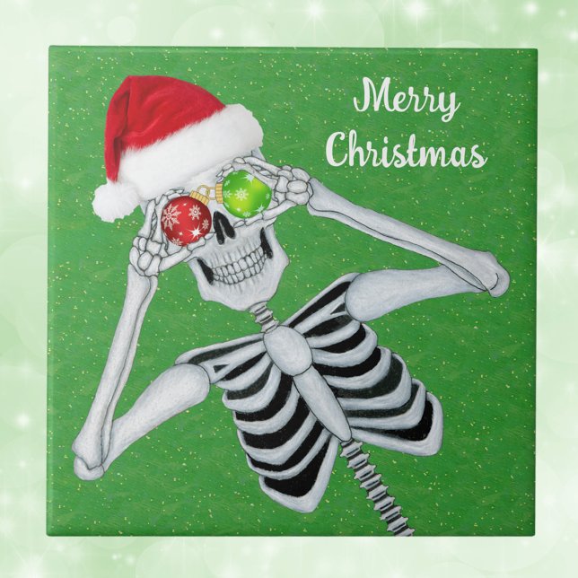 Sväng jul Skeleton Ornament Ögon Grönt Kakelplatta (Green Christmas decorative ceramic tile with Santa skeleton holding ornaments up to eyes.)