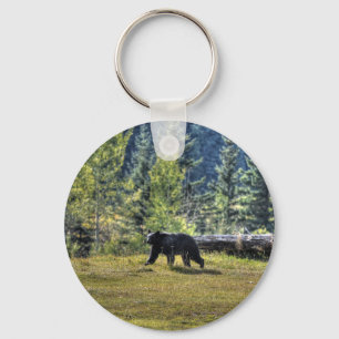 Svart björn som korsar en ranchbetesmark nyckelring