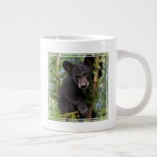 Svart björnunge leker i träden jumbo mugg