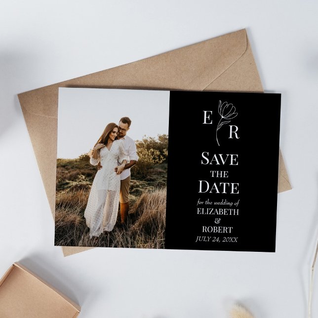 Svart Blommigt Monogram Anpassningsbar Foto Spara  Inbjudningar (Black Floral Monogram Custom Photo Save the Date Invitation on white table with dry wildflowers.)
