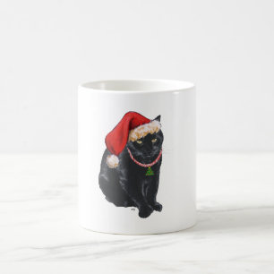 Svart katt i tomteluva kaffemugg