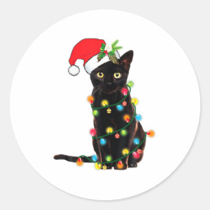 Svart katt jultomte intrasslad i julgransbelysning runt klistermärke