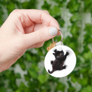 Svart katt på människans rygg nyckelring