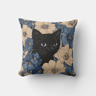 Svart katt som tittar fram genom blåa och krämfärg kudde