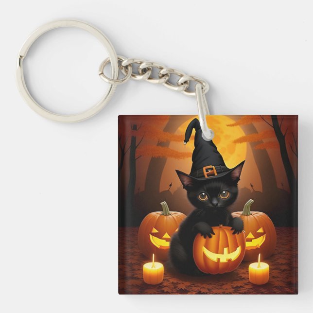 Svart kattunge i häxhatt bland halloweenpumpor (Framsidan)