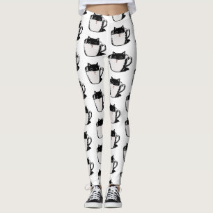 Svart kattunge med röd näsa gömmande i kopp leggings