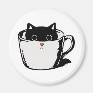 Svart kattunge med röd näsa gömmande i kopp magnet