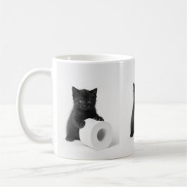 Svart kattunge vaktar toarulle på kaffemugg