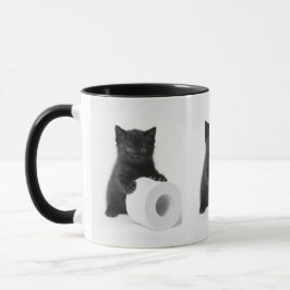 Svart kattunge vaktar toarulle på mugg