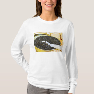 Svart kaviar och en sked av pärlemor för t-shirt