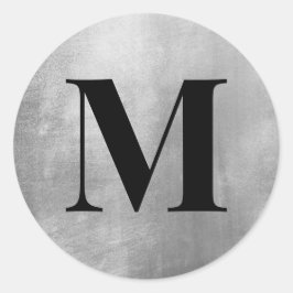 Svart monogram på falskt silverfolie runt klistermärke
