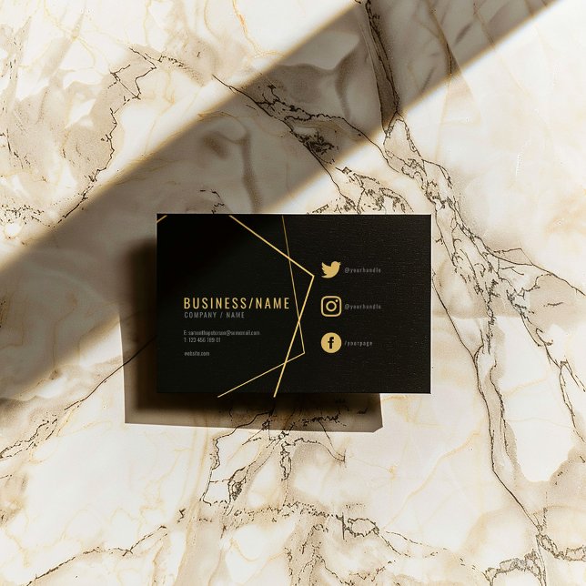 Svart och guld social media visitkort (Black business card with gold geometric lines, social icons, and modern typography.)