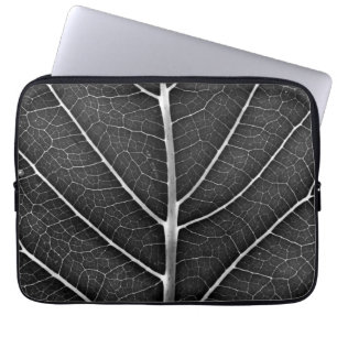 Svart och vit glödande löv nära laptop fodral