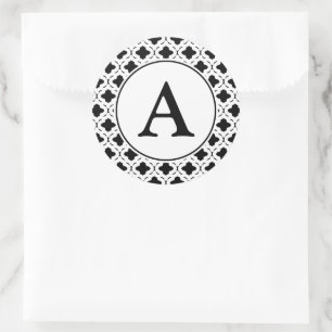 Svarta och vita monogrammärkningar runt klistermärke