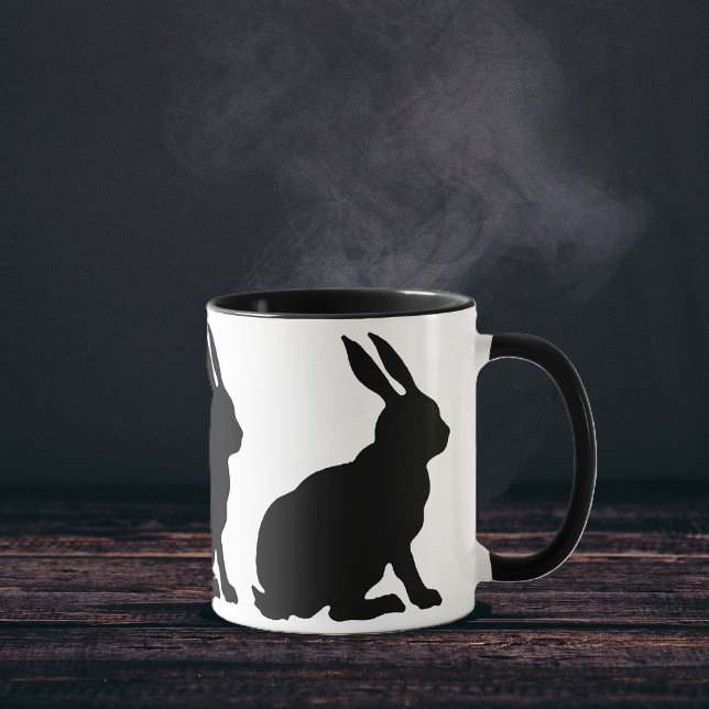 Svarta silhuett kaniner mugg (Ring of sitting black silhouette rabbits with tall ears on white coffee or tea mug.)