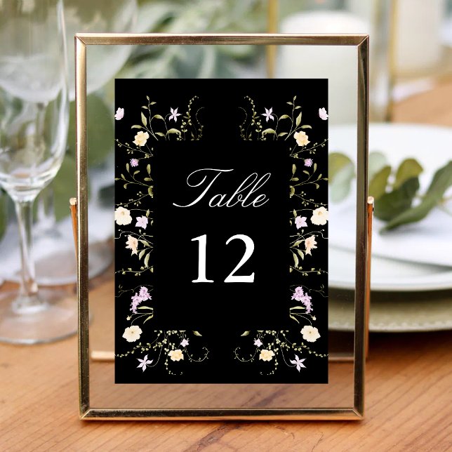 Svarta & Vita Vilda Blommor Bröllopskalligrafi Bordsnummer (Black and white wildflowers calligraphy table number guides guests with elegant floral charm.)