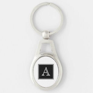 Svarten kvadrerar Monogrammetall Keychain Ovalt Silverfärgad Nyckelring