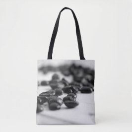 Svartvita kaffebönor spridda tygkasse